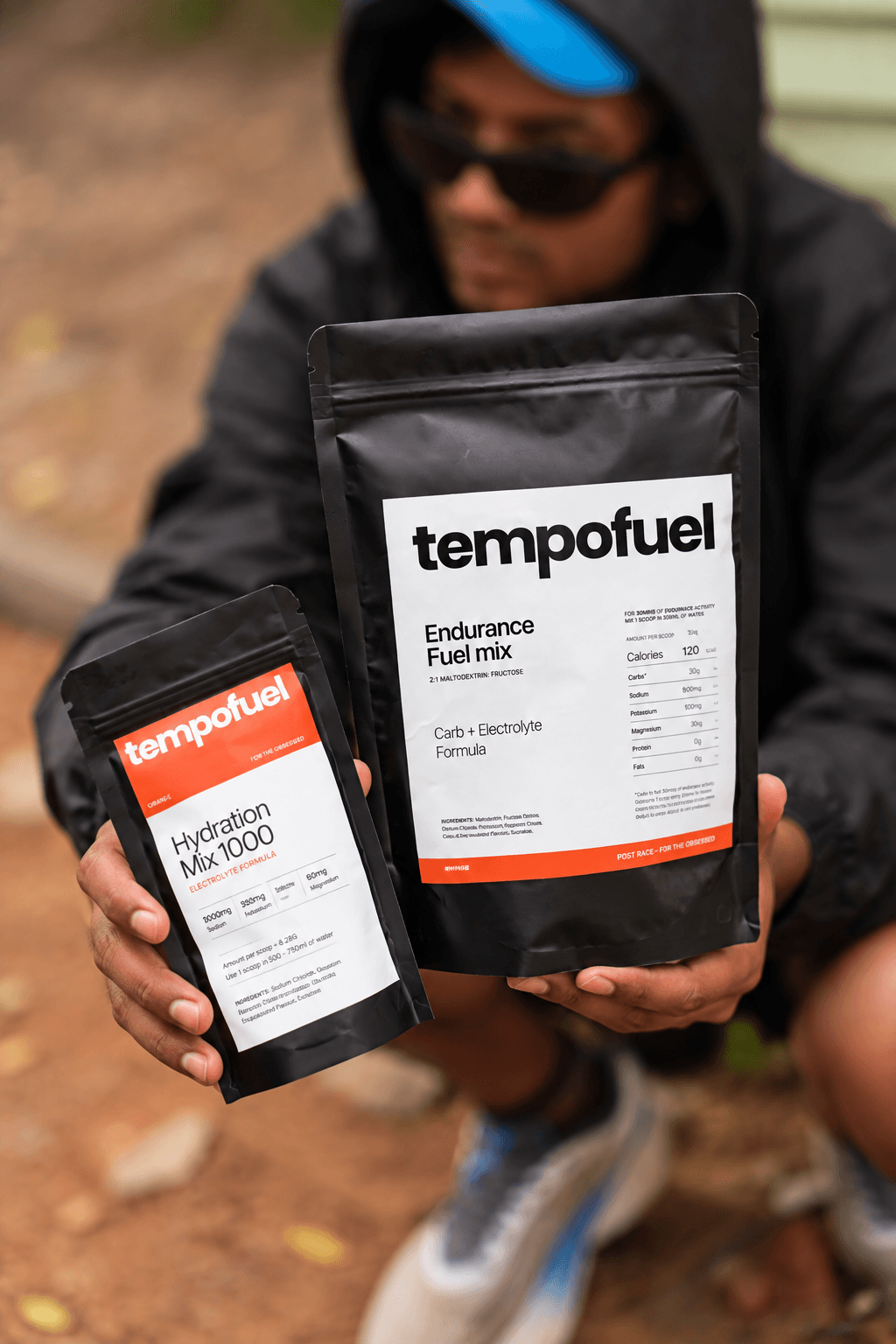 Tempo Fuel Endurance and Hydration pouches in focus with the athlete behind them